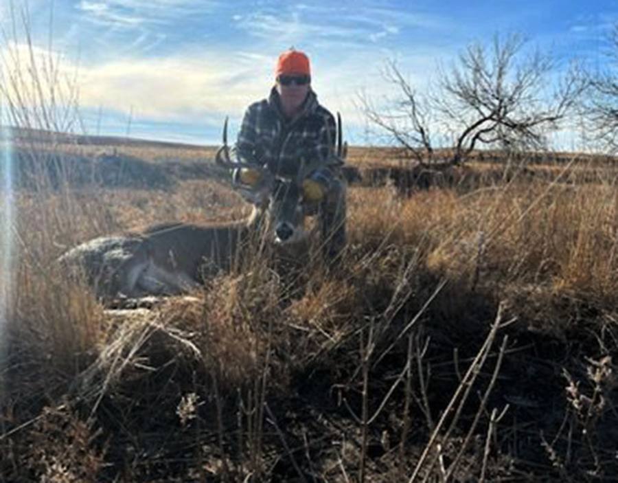Hunter with a wide-antlered mule deer in the Cheyenne River breaks
