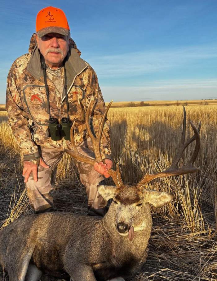 Hunter with a four-point-on-one-side buck